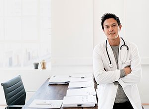 male provider smiling at desk