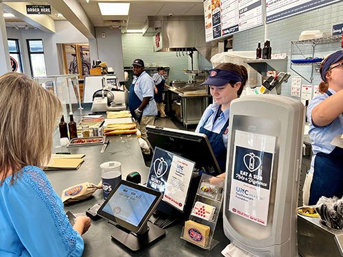 Jersey Mikes employee serving food at restaurant